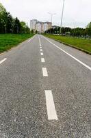 een leeg stad fiets pad langs een stad straat in zomer foto