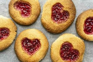 eigengemaakt koekjes versierd met framboos jam in de vorm van een hart foto