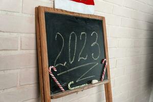 een zwart leisteen Aan welke de jaar 2023 is geschreven in krijt. gelukkig nieuw jaar. foto