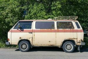 een oud wijnoogst roestig minibus staand in de tuin. hippie cultuur foto