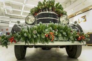 wijnoogst auto is versierd met Spar takken en Kerstmis decoraties foto