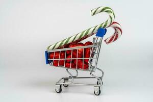 een supermarkt trolley geladen met snoepjes en Kerstmis karamel wandelstokken foto