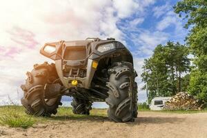 atv Aan de zanderig kust van de meer Aan de achtergrond van de kamp foto