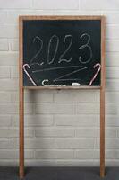 een zwart leisteen Aan welke de jaar 2023 is geschreven in krijt. gelukkig nieuw jaar. foto