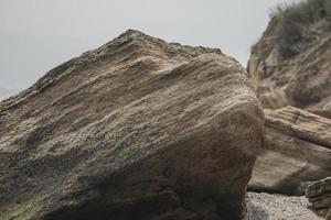 op het strand liggen grote keien foto