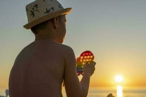 kind spelen met een regenboog knal het, persen bubbels. anti stress speelgoed- foto