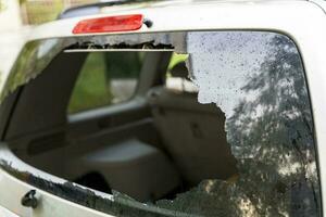 gebroken achterzijde venster van de auto. de stoffelijk overschot van auto glas in de venster foto