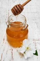 honing en jasmijnbloemen op een houten achtergrond foto