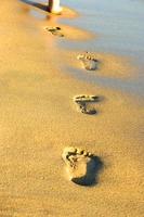 voetafdrukken in het gouden zand op het strand in spanje, palma de mallorca foto