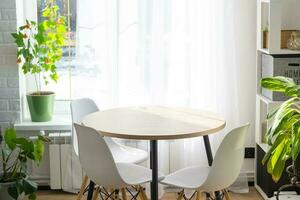 de interieur van de huis met groot ramen en huis planten ronde tafel, stoelen, wit zolder. minimalisme, wit gordijn foto