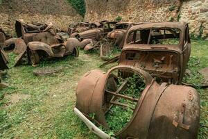 oud roestig auto's links achter in oradour-sur-gllane, Frankrijk. foto