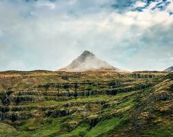 robuust vulkanisch piramide vorm en klifbrekkufossar multi waterval in mijnjoifjordur fjord Aan zomer foto