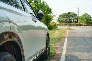 wit modern suv auto met bekladden asfalt geparkeerd Aan langs de weg foto