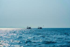 visvangst boot drijvend Aan blauw zee foto