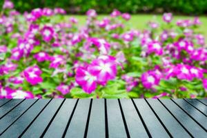 hout tafel top Aan wazig waterkers, vinca bloem struik foto