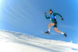 een sportman springt in de sneeuw foto