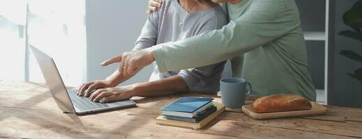 omarmd volwassen paar surfing de internet Aan laptop Bij huis foto