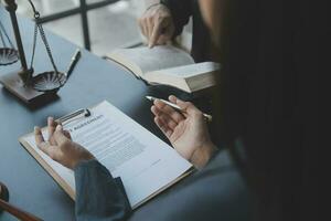 mannelijke advocaat die met contractdocumenten en houten hamer op tafel in rechtszaal werkt. justitie en recht, advocaat, rechter, concept. foto