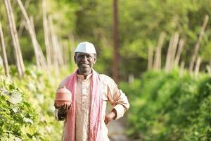 Indisch landbouw gelukkig boer Holding varkentje bank in boerderij, arm boer, boer besparing foto