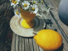 citroen en bloemen in geel vaas nog steeds leven foto