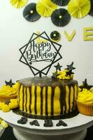 verjaardag taart versierd met zwart en geel botercrème glazuur. foto