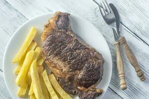 rundvlees steak met gebakken aardappelen Aan de bord foto