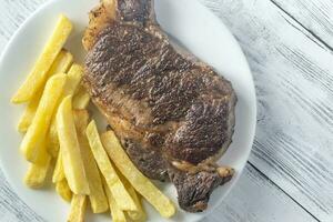 rundvlees steak met gebakken aardappelen Aan de bord foto