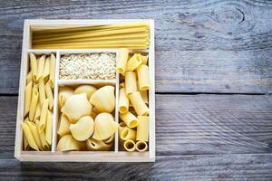 divers types van pasta in de houten houder foto