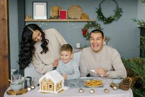 een elegant gelukkig familie siert een peperkoek huis foto