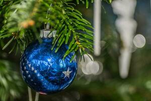 blauw kom met sterren hangende Bij de Kerstmis boom foto