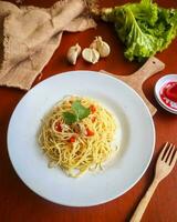 aglio e olie. Italiaans pasta spaghetti, aglio olio e peperoni ,spaghetti met knoflook, olijf- olie en chili paprika's Aan bord Aan tafel foto