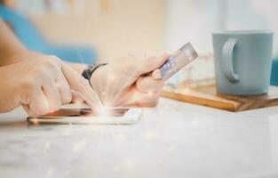 vinger vrouw tintje Aan scherm mobiel telefoon en Holding credit kaart foto