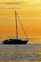 zeilboot bij zonsondergang foto