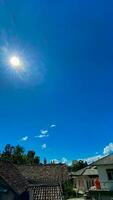 een blauw lucht met wolken en een zon foto