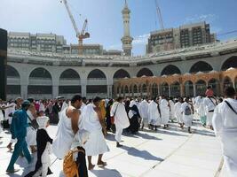 mekka, saudi Arabië, april 2023 - pelgrims van verschillend landen van de wereld zijn het uitvoeren van tawaf in de binnenplaats van masjid al-haram in mekka gedurende de dag. foto