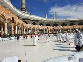 mekka, saudi Arabië, april 2023 - pelgrims van verschillend landen van de wereld zijn het uitvoeren van tawaf in de binnenplaats van masjid al-haram in mekka gedurende de dag. foto