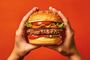 handen Holding een Hamburger geïsoleerd Aan oranje achtergrond. ai gegenereerd foto