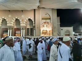 medina, saudi Arabië, mei 2023 - mooi nacht tijd visie van masjid al nabawi, medina. bezoekers, binnenplaatsen buiten de moskee, mooi lichten en elektronisch paraplu's kan ook worden gezien. foto