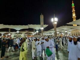 medina, saudi Arabië, mei 2023 - mooi nacht tijd visie van masjid al nabawi, medina. bezoekers, binnenplaatsen buiten de moskee, mooi lichten en elektronisch paraplu's kan ook worden gezien. foto