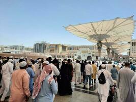 medina, saudi Arabië, mei 2023 - een mooi dag visie van masjid al nabawi, medina's buitenste binnenplaats, pelgrims en moskee luifels. foto