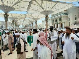 medina, saudi Arabië, mei 2023 - een mooi dag visie van masjid al nabawi, medina's buitenste binnenplaats, pelgrims en moskee luifels. foto