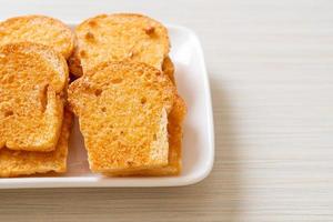 gebakken krokant brood met boter en suiker op een bord foto