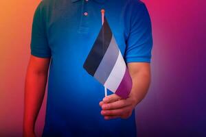 hand- Holding vlag in aseksueel trots kleuren. foto