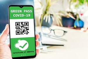 gevaccineerd persoon gebruik makend van digitaal Gezondheid paspoort app in mobiel telefoon voor reizen gedurende covid-19 pandemie. digitaal groen certificaat. foto