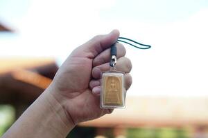 hand- houdt Boeddha amulet. concept, geloof en geloof van boeddhistisch voor heilig naar beschermen van gevaren, brengen mooi zo geluk, bedrijf welvaart en rijkdom. verzamelen amulet net zo hobby's, aandelenbeurs, verkopen of kopen. foto