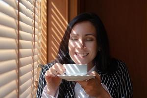portret van jonge mooie zakenvrouw die koffie drinkt tijdens de pauze break foto