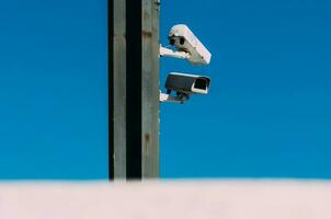 ik p cctv camera of toezicht camera voor veiligheid Aan een poll met blauw lucht en wolk achtergrond. foto