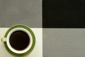 kop van koffie Aan de zwart en wit stoffen tafel foto
