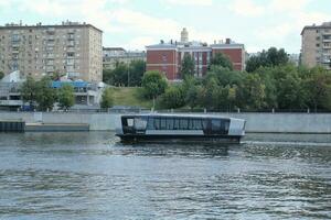 waterbus boot Aan moskee rivier. elektrisch schip Bij Moskou openbaar vervoer. ecologisch technologie. groen energie in stad route. dagelijks passagier veerboot onderhoud. Moskou, Rusland - juni 22, 2023. foto