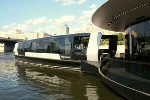 waterbus boot Aan moskee rivier. elektrisch schip Bij Moskou openbaar vervoer. ecologisch technologie. groen energie in stad route. dagelijks passagier veerboot onderhoud. Moskou, Rusland - juni 22, 2023. foto